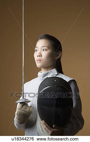 Stock Photograph - Close-up of a female fencer holding a sword and a fencing mask. Fotosearch
