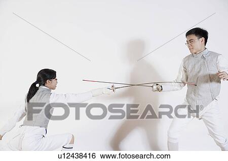 Stock Photograph - Male and a female fencer fencing. Fotosearch