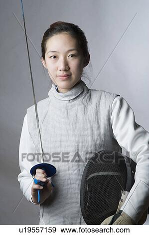 Portrait of a female fencer holding a sword and a fencing mask View Large Photo Image Stock Photo - Portrait of a female fencer holding a sword and a fencing mask. Fotosearch
