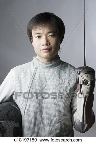 Portrait of a male fencer holding a sword and a fencing mask View Large Photo Image Stock Photo - Portrait of a male fencer holding a sword and a fencing mask. Fotosearch