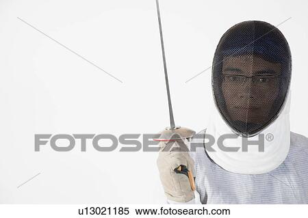 Stock Photography - Portrait of a male fencer wearing fencing mask and holding a fencing foil. Fotosearch