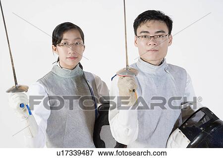 Portrait of a male with a female fencer holding fencing masks and fencing foils View Large Photo Image Stock Photo - Portrait of a male with a female fencer holding fencing masks and fencing foils. Fotosearch