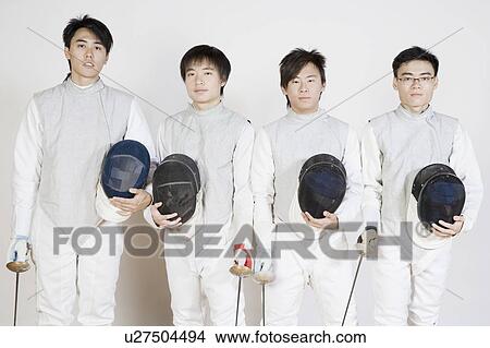 Picture - Portrait of four male fencers holding fencing foils and fencing masks. Fotosearch