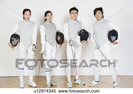 Stock Photography - Portrait of two male and two female fencers holding fencing masks with fencing foils. Fotosearch