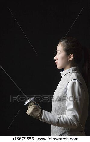 Side profile of a female fencer holding a fencing foil View Large Photo Image Stock Photograph - Side profile of a female fencer holding a fencing foil. Fotosearch