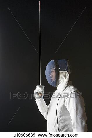 Stock Photo - Side profile of a male fencer holding a fencing foil. Fotosearch