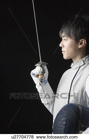 Side profile of a male fencer holding a fencing foil and a fencing mask View Large Photo Image Stock Photo - Side profile of a male fencer holding a fencing foil and a fencing mask. Fotosearch