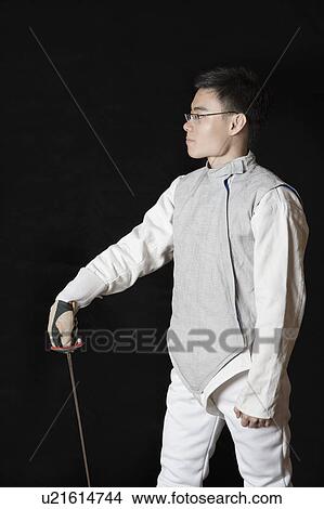 Picture - Male fencer holding a fencing foil. Fotosearch