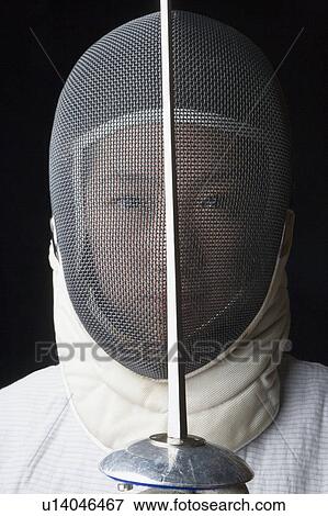 Portrait of a female fencer holding a fencing foil in front of her View Large Photo Image Stock Photo - Portrait of a female fencer holding a fencing foil in front of her. Fotosearch