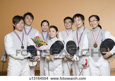 Portrait of a group of people in fencing costumes wearing medals and smiling View Large Photo Image Picture - Portrait of a group of people in fencing costumes wearing medals and smiling. Fotosearch