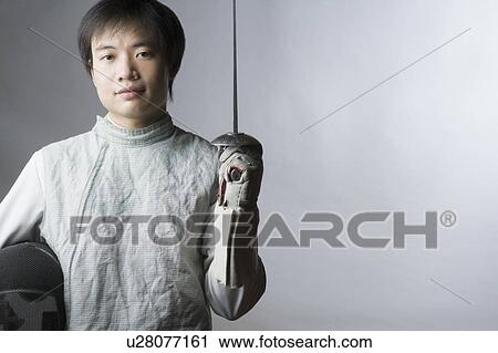 Portrait of a male fencer holding a sword and a fencing mask View Large Photo Image Stock Image - Portrait of a male fencer holding a sword and a fencing mask. Fotosearch