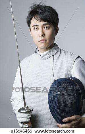 Stock Photography - Portrait of a male fencer holding a sword and a fencing mask. Fotosearch