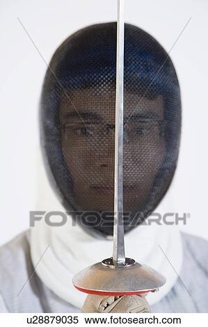 Stock Photography - Portrait of a man wearing a fencing mask and holding a fencing foil. Fotosearch