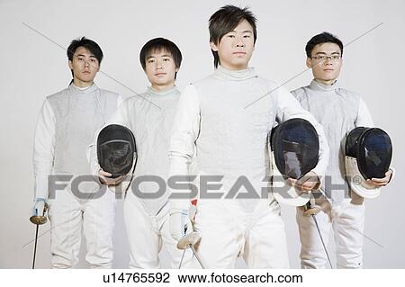 Stock Image - Portrait of four male fencers holding fencing foils and fencing masks. Fotosearch