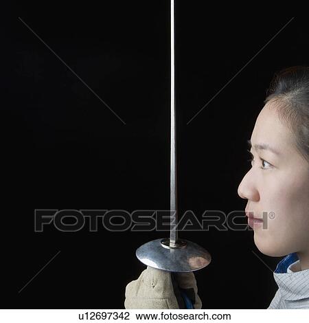 Side profile of a female fencer holding a fencing foil View Large Photo Image Stock Image - Side profile of a female fencer holding a fencing foil. Fotosearch