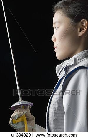 Side profile of a female fencer holding a fencing foil View Large Photo Image Stock Image - Side profile of a female fencer holding a fencing foil. Fotosearch