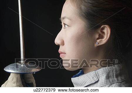 Side profile of a female fencer holding a fencing foil View Large Photo Image Stock Photo - Side profile of a female fencer holding a fencing foil. Fotosearch