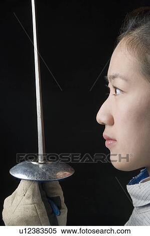 Side profile of a female fencer holding a fencing foil View Large Photo Image Stock Photography - Side profile of a female fencer holding a fencing foil. Fotosearch