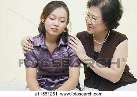 Stock Image - Close-up of a senior woman consoling her daughter. Fotosearch