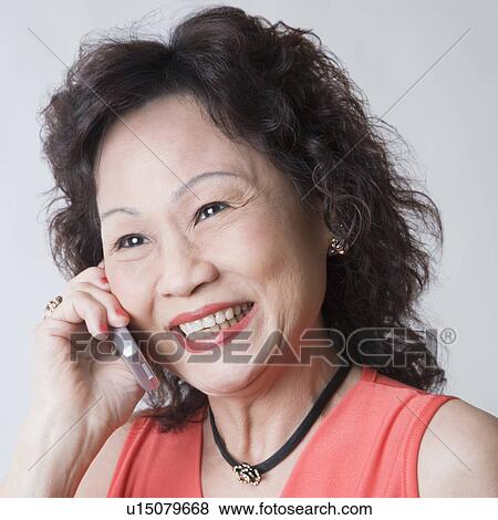 Stock Photo - Close-up of a senior woman talking on a mobile phone and smiling. Fotosearch