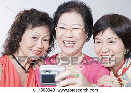 Close-up of three senior women taking a photograph of themselves View Large Photo Image Stock Image - Close-up of three senior women taking a photograph of themselves. Fotosearch