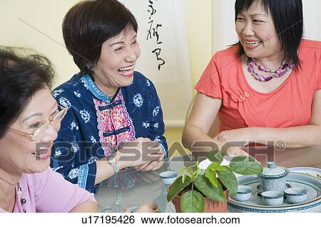 Close-up of two senior women and a mature woman sitting at a table View Large Photo Image Stock Photograph - Close-up of two senior women and a mature woman sitting at a table. Fotosearch