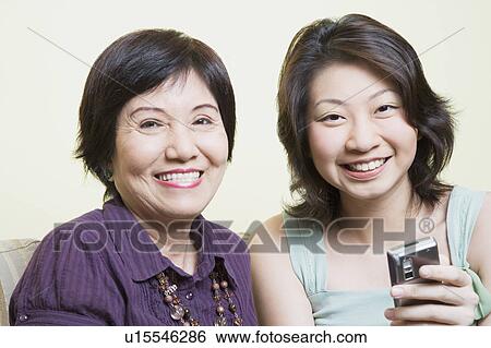 Portrait of a senior woman sitting with her granddaughter and smiling View Large Photo Image Stock Photograph - Portrait of a senior woman sitting with her granddaughter and smiling. Fotosearch