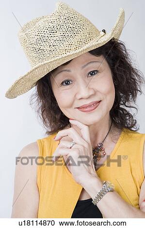 Stock Image - Portrait of a senior woman smiling with her hand on her chin. Fotosearch