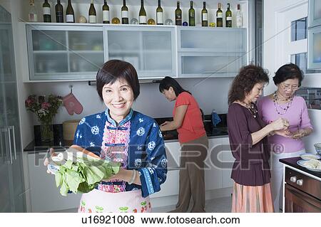 Three senior women and a mature woman preparing food in a domestic kitchen View Large Photo Image Stock Photo - Three senior women and a mature woman preparing food in a domestic kitchen. Fotosearch