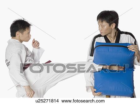 Picture - Male karate instructor teaching martial arts to a young man. Fotosearch
