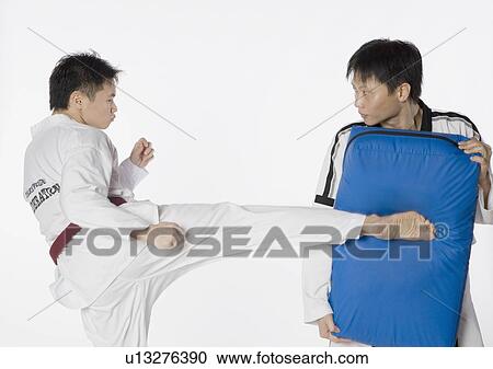 Male karate instructor teaching martial arts to a young man View Large Photo Image Stock Image - Male karate instructor teaching martial arts to a young man. Fotosearch
