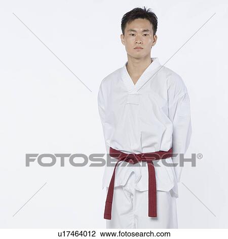 Portrait of a young man standing with his hands behind his back View Large Photo Image Stock Image - Portrait of a young man standing with his hands behind his back. Fotosearch