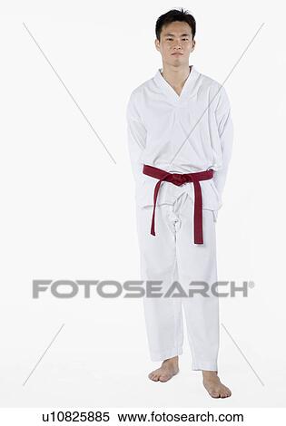 Portrait of a young man standing with his hands behind his back View Large Photo Image Stock Photography - Portrait of a young man standing with his hands behind his back. Fotosearch