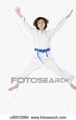 Picture - Portrait of a young woman jumping and practicing martial arts. Fotosearch