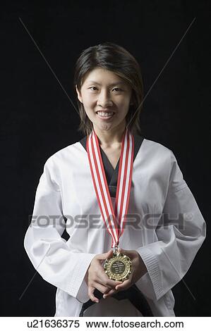 Portrait of a young woman standing with a medal around her neck View Large Photo Image Stock Photography - Portrait of a young woman standing with a medal around her neck. Fotosearch