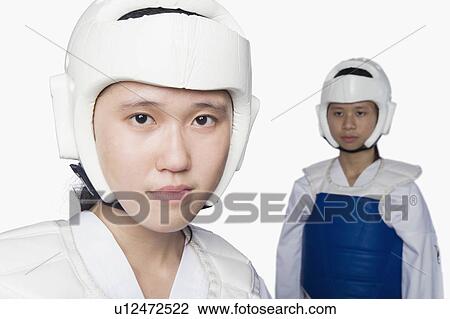 Stock Image - Portrait of a young woman wearing a sports helmet with another young woman standing in the background. Fotosearch