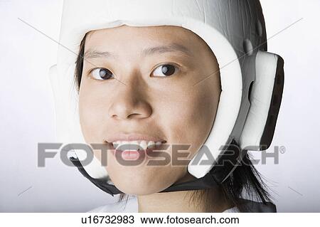 Stock Image - Portrait of a young woman wearing a sports helmet. Fotosearch