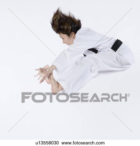Side profile of a young woman jumping and practicing martial arts View Large Photo Image Stock Image - Side profile of a young woman jumping and practicing martial arts. Fotosearch