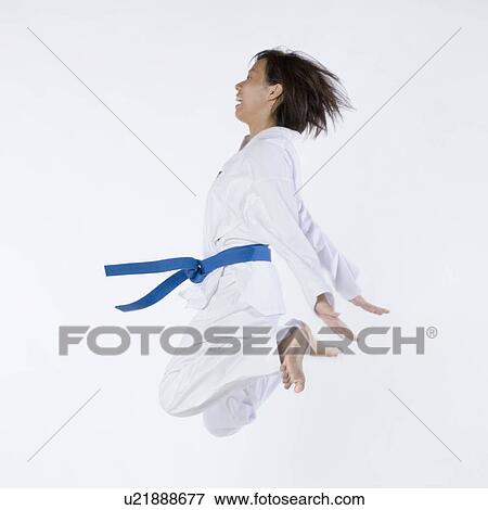 Side profile of a young woman jumping and practicing martial arts View Large Photo Image Stock Photo - Side profile of a young woman jumping and practicing martial arts. Fotosearch