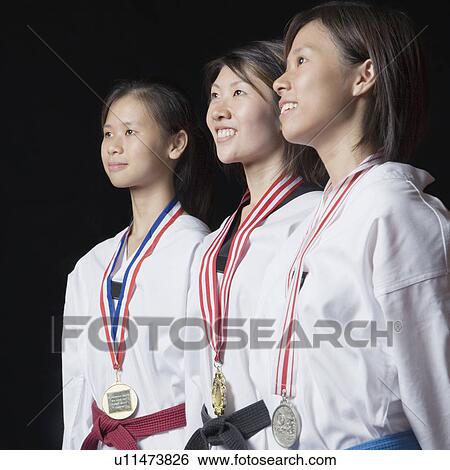 Stock Photograph - Three young women standing with their medals. Fotosearch