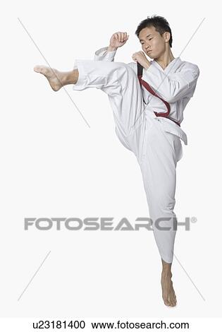 Stock Image - Young man kicking. Fotosearch