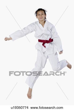 Picture - Young woman jumping and practicing martial arts. Fotosearch