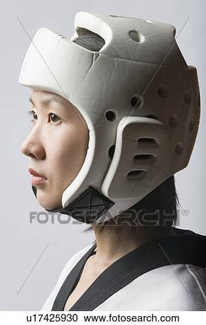 Stock Image - Close-up of a young woman wearing a sports helmet. Fotosearch