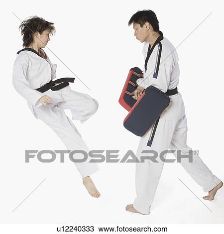 Female karate instructor teaching martial arts to a young man View Large Photo Image Stock Image - Female karate instructor teaching martial arts to a young man. Fotosearch