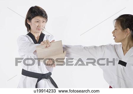 Stock Image - Female karate instructor teaching martial arts to a young woman. Fotosearch