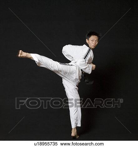 Mid adult man performing the side kick View Large Photo Image Stock Photography - Mid adult man performing the side kick. Fotosearch