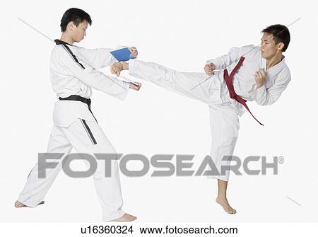 Picture - Mid adult man practicing kickboxing with a young man. Fotosearch