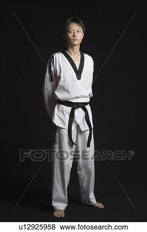Portrait of a mid adult man standing with his hands behind his back View Large Photo Image Stock Photo - Portrait of a mid adult man standing with his hands behind his back. Fotosearch