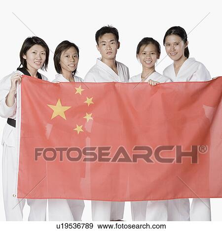 Stock Photo - Portrait of four young women and a young man holding a Chinese flag. Fotosearch
