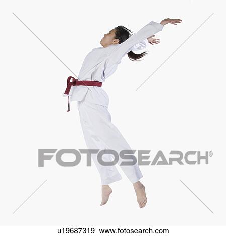 Side profile of a young woman jumping and practicing martial arts View Large Photo Image Stock Photo - Side profile of a young woman jumping and practicing martial arts. Fotosearch